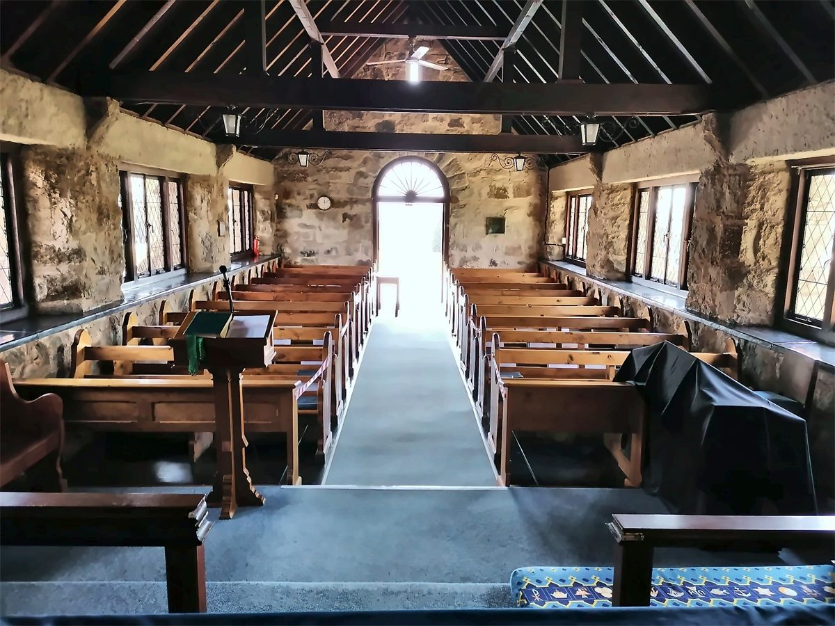 Inside St George's Anglican Church, looking down the nave toward the open door